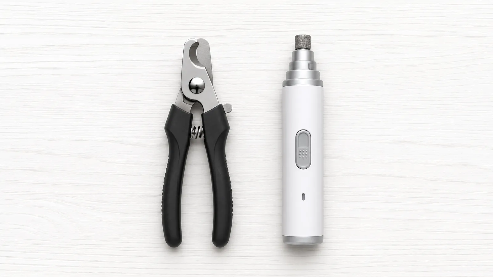 Dog nail clipper and electric nail grinder placed side by side on a clean surface, showing both grooming tool options
